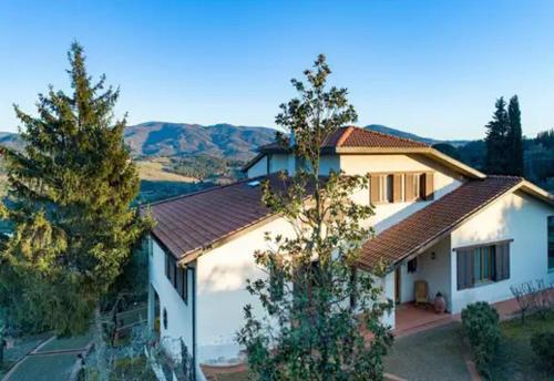 a white house with trees and mountains in the background at Villa Decimo in L'Ugolino