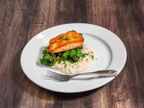 a white plate with fish and rice and broccoli at Holiday Inn & Suites Philadelphia W - Drexel Hill by IHG in Drexel Hill