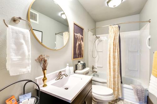 a bathroom with a sink and a toilet and a mirror at Historic Vacation Rental in Downtown Rapid City! in Rapid City