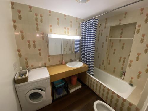 La petite salle de bains est pourvue d'un lavabo et d'un lave-linge. dans l'établissement Bel Appartement face mer - GARAGE, à Les Sables-dʼOlonne