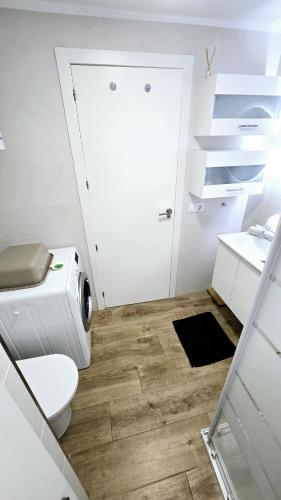 a bathroom with a toilet and a washing machine at Ocean View Luxury Las Americas in Playa de las Americas