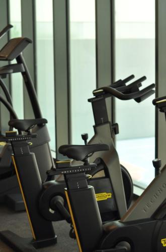 a row of exercise bikes in a gym at EC Holiday Homes Dubai Al Furjan in Dubai