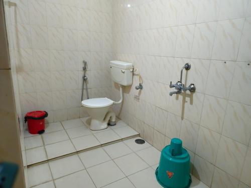 a bathroom with a toilet in a tiled room at Orion Seaview Beach Hotel in Kovalam