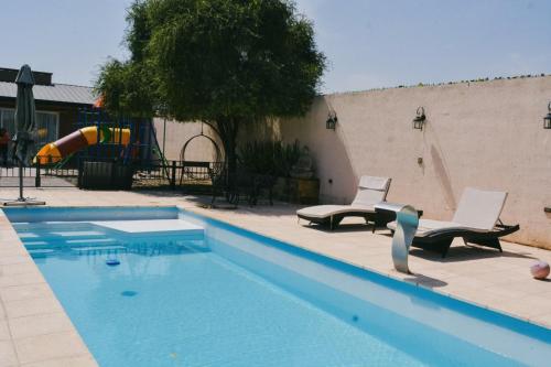 a swimming pool with two chairs and a slide at Depto alaniz salinas in La Rioja