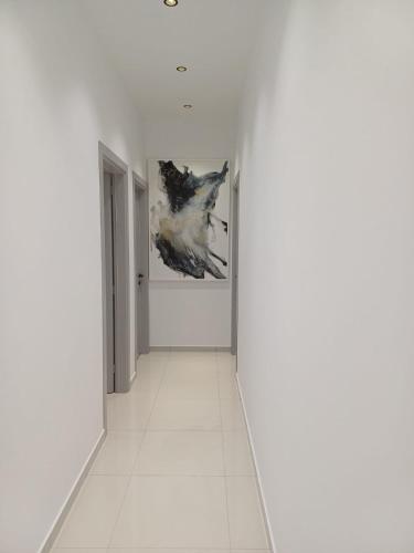 a hallway with white walls and a painting on the wall at Summer Hotel in Vlorë