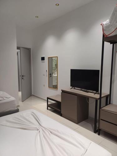 a bedroom with a bed and a desk with a television at Summer Hotel in Vlorë