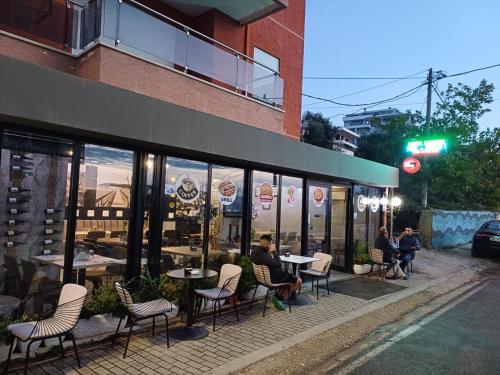a group of people sitting at tables outside a restaurant at Summer Hotel in Vlorë