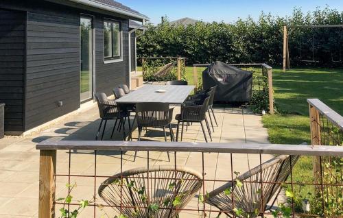 a patio with a wooden table and chairs at Awesome Home In Tarm With Kitchen in Tarm