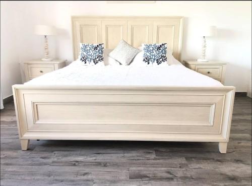 a large white bed with pillows on it in a bedroom at Dickenson Bay Oasis at Antigua Village in Saint Johnʼs