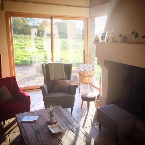 un salon avec une table et une cheminée dans l'établissement Maison proche Pont l'Eveque Deauville Honfleur, à Les Authieux-sur-Calonne