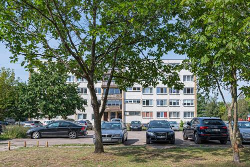 a parking lot with cars parked in front of a building at Pramonės Apartment #11 by PoloApartments in Kaunas