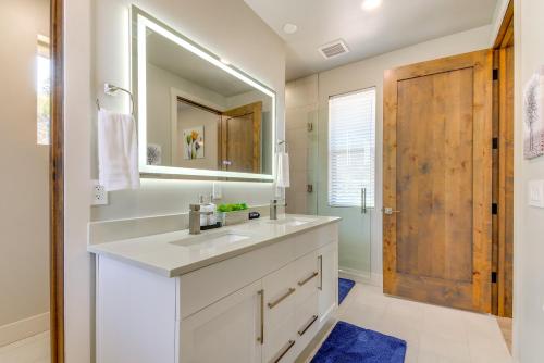 a bathroom with a white sink and a wooden door at Mtn-View Retreat with Game Room in Prescott! in Prescott