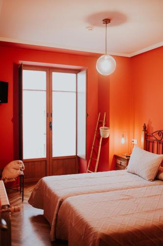 a bedroom with orange walls and a large bed at Casa Rural Osingain in Caicedo Yuso