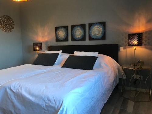 a bedroom with a large white bed with two lamps at Casa Bella Ella in Vinningen