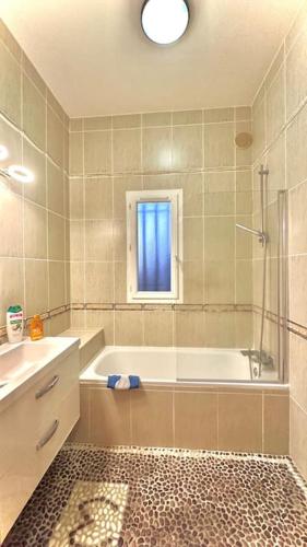 une salle de bain avec une baignoire, une douche et un lavabo dans l'établissement La villa Soleil, à Fourques