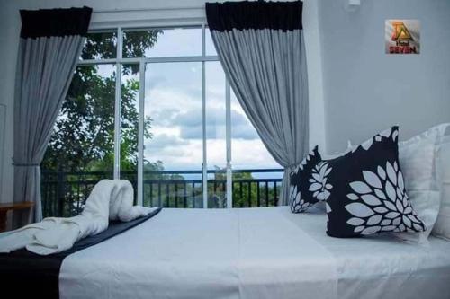 a bedroom with a bed with a large window at White House Inn in Lukasgoda