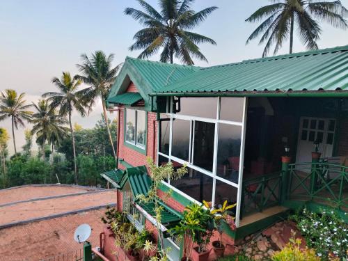 a house with palm trees in the background at Nestinggrounds in Mudigere