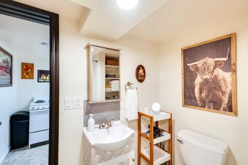 ラピッドシティにあるCentrally Located Apt Near Downtown Rapid City!のバスルーム(シンク付)が備わります。壁に牛の絵が描かれています。