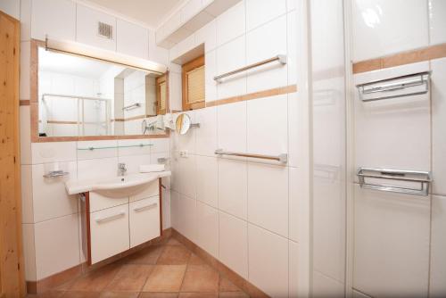 a white bathroom with a sink and a mirror at Almhäuser Filzsteinalpe Almhaus 196 in Krimml
