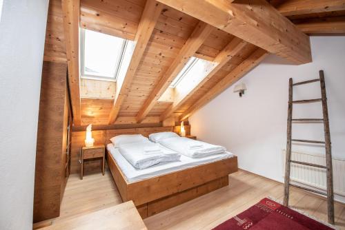 a attic bedroom with a bed and a ladder at Almhäuser Filzsteinalpe Almhaus 196 in Krimml