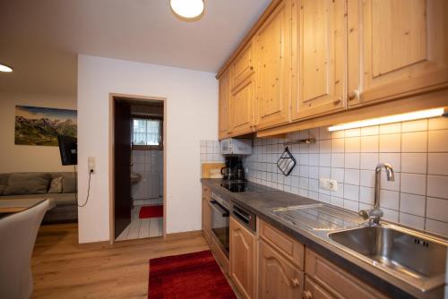 een keuken met houten kasten en een spoelbak bij Chalet Alpine Royal B Top 20 in Krimml
