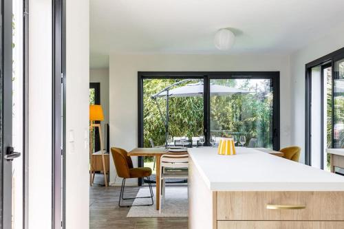 une cuisine et une salle à manger avec une table et des chaises dans l'établissement Contemporaine à Saint-Trojan à moins de 200, à Saint-Trojan-les-Bains