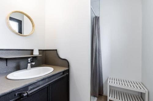 une salle de bain avec un lavabo et un miroir dans l'établissement Contemporaine à Saint-Trojan à moins de 200, à Saint-Trojan-les-Bains