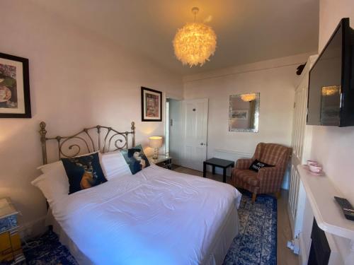 a bedroom with a bed and a chandelier at Deluxe Three Bed BnB in Henley-on-Thames near Station River & Town Centre in Henley on Thames