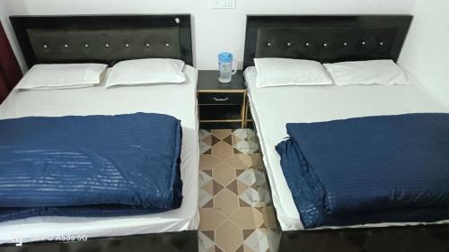 two beds sitting next to each other in a room at Hill View Hotel & Tourist Lodge in Rudraprayāg