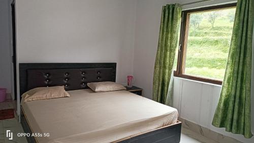 a bedroom with a bed with a large window at Hill View Hotel & Tourist Lodge in Rudraprayāg