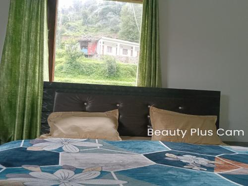 a bedroom with a bed with a large window at Hill View Hotel & Tourist Lodge in Rudraprayāg