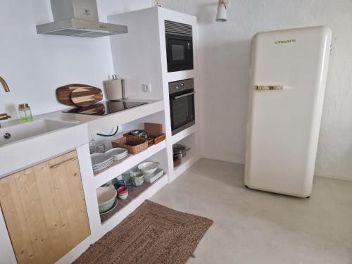 a kitchen with a white refrigerator and a sink at Da Calcada ao Rio in Alcácer do Sal