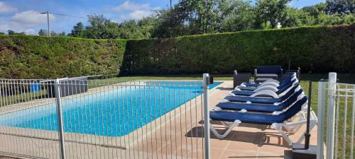 a group of blue lounge chairs next to a swimming pool at Labouysse in Montcuq