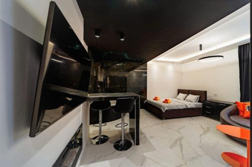 a living room with a bed and a bar with stools at Dark Nest 3 Belgrade Apartments in Zvezdara