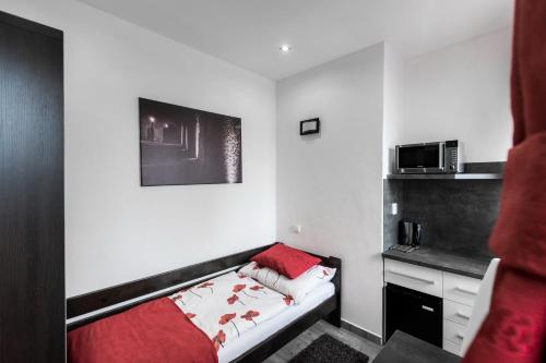 a small bedroom with a bed and a microwave at Hotel Apartments Benešova 6 in Kutná Hora