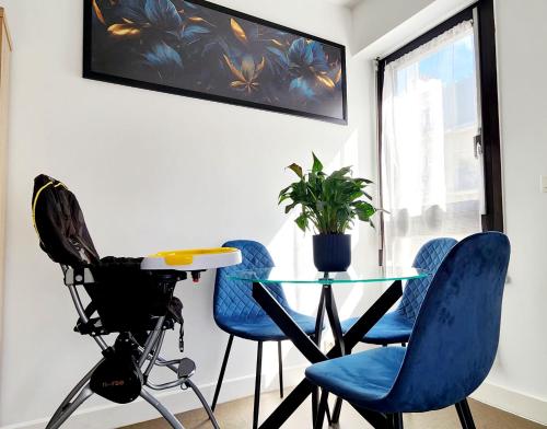 - une salle à manger avec une table, des chaises et une caméra dans l'établissement Village Faidherbe Appartement d'Angle Moderne, à Paris