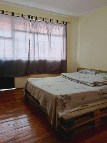 a bed in a room with a large window at Albergue Camry Backpackers佳美背包客旅馆 in Cuenca
