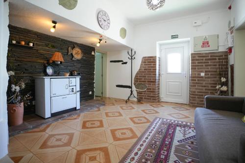 a living room with a couch and a brick wall at A Janela das Palmeiras in Reguengos de Monsaraz