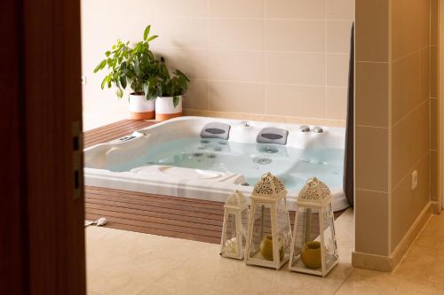 a jacuzzi tub in a bathroom with a plant at Countryside Villa near Porto in Paredes