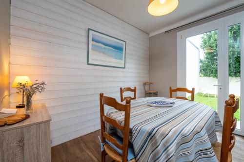 une salle à manger avec une table et une fenêtre dans l'établissement Maison de vacances 50m de la plage, à Larmor-Plage