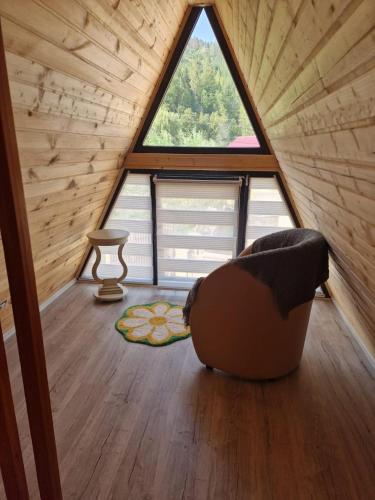 a room in a tiny house with a large window at Bucovina-A-FrameHouse-HotTub-Fireplace-Patio-WiFi in Suceviţa