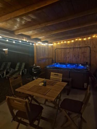 a room with a table and a tub with lights at Bucovina-A-FrameHouse-HotTub-Fireplace-Patio-WiFi in Suceviţa