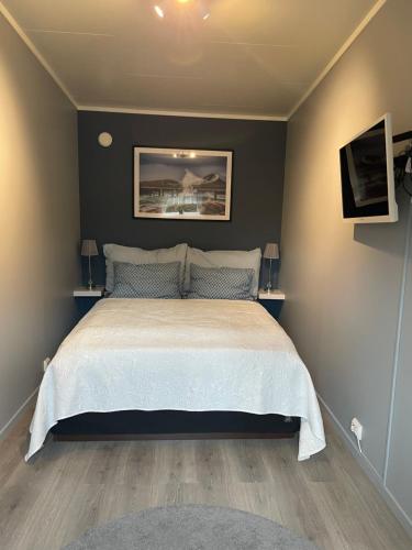 a bedroom with a bed with a white bedspread at Small cozy apartment in Tromsø
