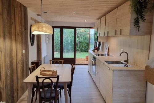 une cuisine et une salle à manger avec une table et des chaises dans l'établissement Charmant Chalet Hiona, à Bolquère-Pyrénées 2000
