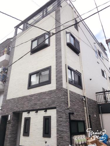 a tall brick building with windows on the side of it at Dain Hostel1 in Tokyo