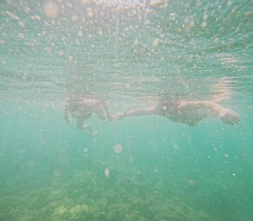 two people swimming in the water in the ocean at Studio Seaview Jomtien floor12 23sqm in Jomtien Beach