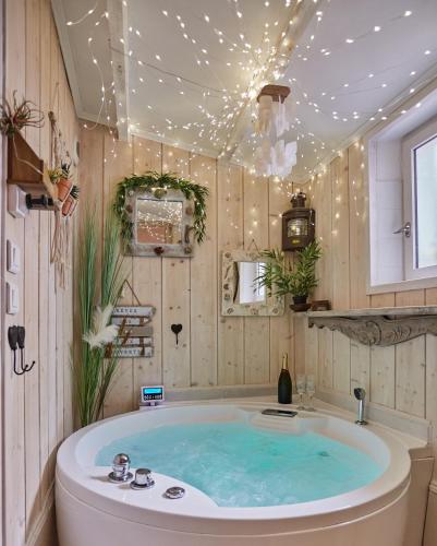 La salle de bains est pourvue d'une baignoire et de lumières au plafond. dans l'établissement Appart Aix sauna jacuzzi balneo spa privatifs hyper centre historique cour intérieur, à Aix-en-Provence