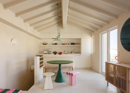 - une cuisine avec une table et un tabouret dans une pièce dans l'établissement Goudes times - cabanon design en bord de mer, à Les Goudes
