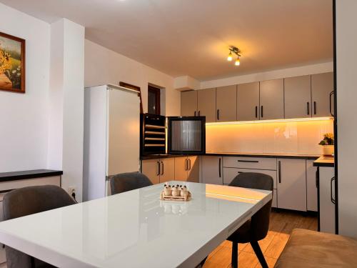 a kitchen with a white table and a refrigerator at Casa Maria in Streiu