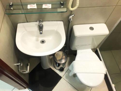 a bathroom with a white toilet and a sink at Hotel Atlantico Macaé By Inn House in Macaé